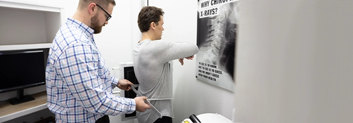 Chiropractor Prosper TX Daniel Noble Examining Athletic Patient